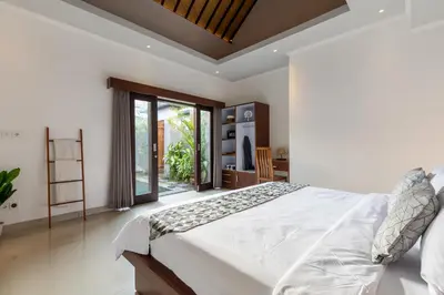 a bedroom with a large bed and a large window at Villa Estella ☆ Seminyak Kuta - Private Pool in Seminyak