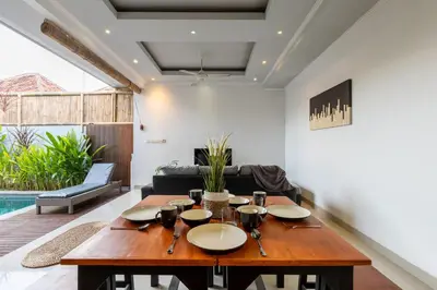 a dining room with a table and a couch at Villa Estella ☆ Seminyak Kuta - Private Pool in Seminyak