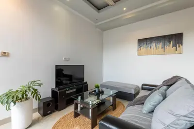 a living room with a couch and a tv at Villa Estella ☆ Seminyak Kuta - Private Pool in Seminyak