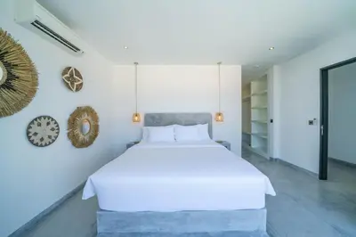 a bedroom with a white bed and a clock on the wall at Villa Bali Townhouse 3 - Modern 2BR Villa with pool - PERFECT LOCATION in Canggu