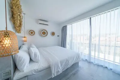 a bedroom with a bed and a large window at Villa Bali Townhouse 3 - Modern 2BR Villa with pool - PERFECT LOCATION in Canggu