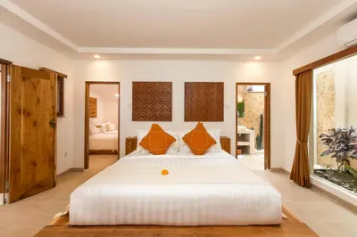 a bedroom with a large white bed with orange pillows at Villa Lisabella by Villa Finder in Seminyak