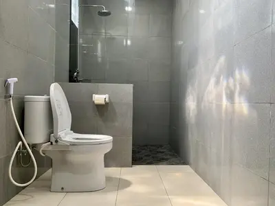 a bathroom with a toilet and a shower at Davit Guesthouse Nusa Dua in Nusa Dua