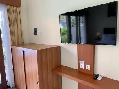 a room with a flat screen tv on a wall at Davit Guesthouse Nusa Dua in Nusa Dua