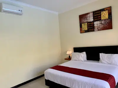 a bedroom with a large white bed in a room at Davit Guesthouse Nusa Dua in Nusa Dua