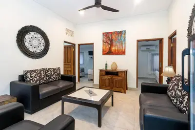 a living room with two couches and a table at Villa Yati in Seminyak