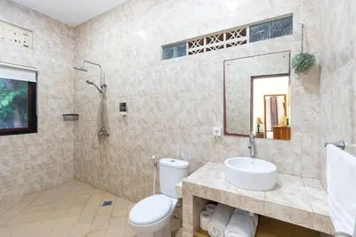 a bathroom with a toilet and a sink and a mirror at Villa Yati in Seminyak
