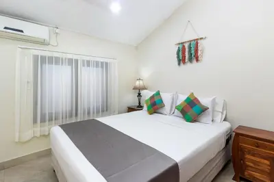 a white bedroom with a large bed and a window at Villa Yati in Seminyak