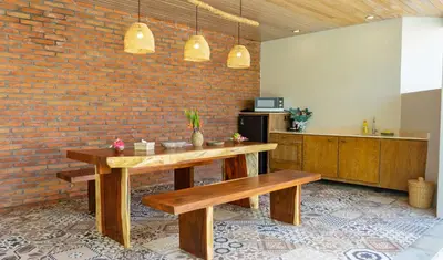 a room with a table and benches and a brick wall at Vivara Bali Private Pool Villas & Spa Retreat in Jimbaran