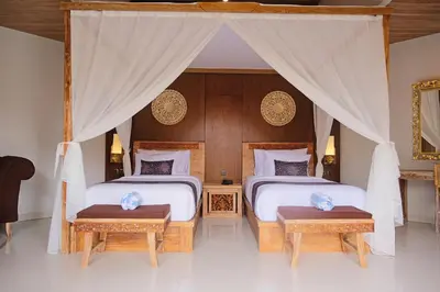 two beds in a room with a canopy bed at Vivara Bali Private Pool Villas & Spa Retreat in Jimbaran