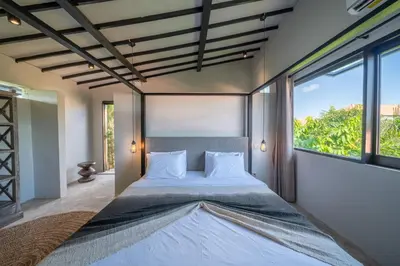 a bedroom with a large bed with a large window at Villa Wiraja 1 - Modern 4 bdr villa in Berawa in Canggu