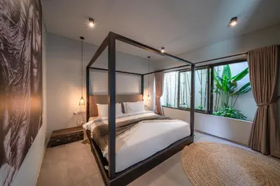 a bedroom with a canopy bed and a window at Villa Wiraja 1 - Modern 4 bdr villa in Berawa in Canggu