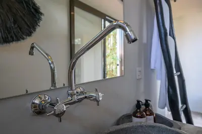 a bathroom sink with a faucet and a mirror at Villa Wiraja 1 - Modern 4 bdr villa in Berawa in Canggu