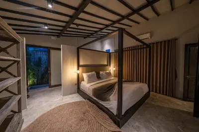 a bedroom with a canopy bed and a large window at Villa Wiraja 2 - Classy 4 bdr villa in the heart for Canggu in Canggu