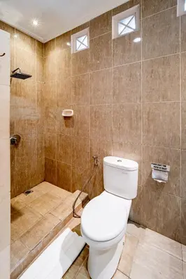 a bathroom with a toilet and a shower at Villa Margaretta in Seminyak