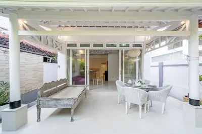 a patio with a bench and a table and chairs at Villa Margaretta in Seminyak