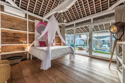 a bedroom with a bed with a mosquito net at Sol Lila Bali in Canggu