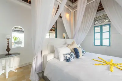 a bedroom with a white bed with white curtains at Sol Lila Bali in Canggu