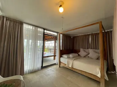 a bedroom with a bed and a large window at Modern Balinese Villa with Scenic View in Nusa Dua