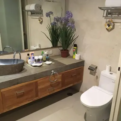 a bathroom with a sink and a toilet and a mirror at Modern Balinese Villa with Scenic View in Nusa Dua