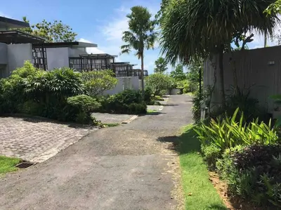 a driveway leading to a house with palm trees at Modern Balinese Villa with Scenic View in Nusa Dua