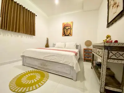 a bedroom with a bed and a table in it at Timaya Villa BEST LOCATION in Legian