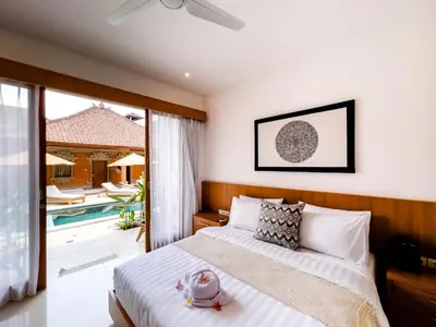 a bedroom with a bed and a pool at Puspa Ayu Villas & Apartments in Kuta