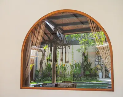 an arched window with a giraffe through it at Lamoon Villas Berawa in Canggu
