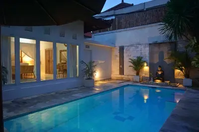 a swimming pool in a villa at night at Villa Noni Seminyak in Seminyak