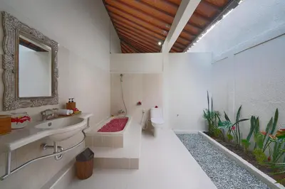 a bathroom with a sink and a toilet and a mirror at Villa Noni Seminyak in Seminyak