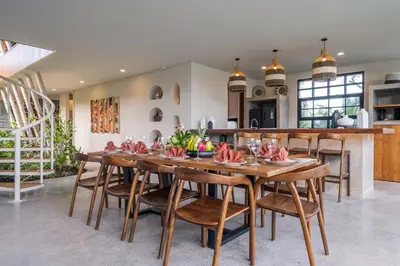 a kitchen and dining room with a wooden table and chairs at Villa Annabelle Canggu in Kerobokan