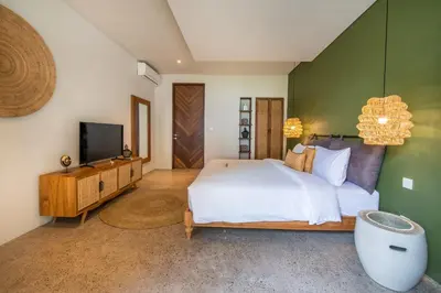 a bedroom with a bed and a flat screen tv at Villa Annabelle Canggu in Kerobokan