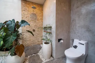 a bathroom with a toilet and two potted plants at Villa Annabelle Canggu in Kerobokan