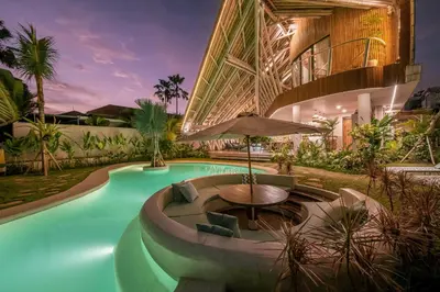 a pool with a table and an umbrella in front of a building at Villa Annabelle Canggu in Kerobokan