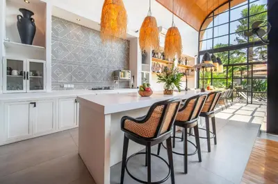 a kitchen with a bar with stools at Villa Yukiko Canggu in Canggu