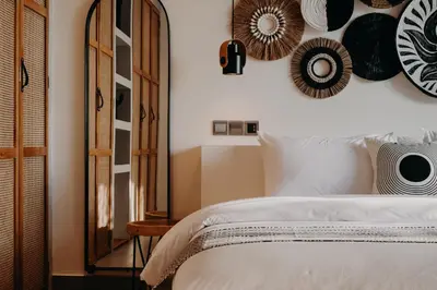 a bedroom with a white bed and plates on the wall at Villa Yukiko Canggu in Canggu