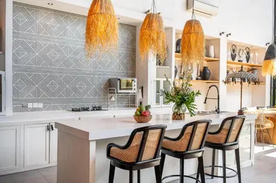 a kitchen with a large white island with bar stools at Villa Yukiko Canggu in Canggu
