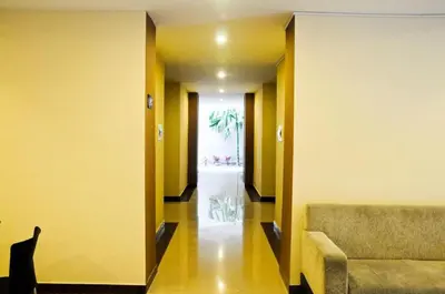 a hallway with a chair and a couch in a building at Collection O Near Bajra Sandi Monumen Formerly Grand Pondok Puri Ayu in Denpasar