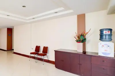 a waiting room with two chairs and a counter with a barrel at Collection O Near Bajra Sandi Monumen Formerly Grand Pondok Puri Ayu in Denpasar