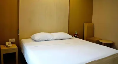 a bed with a white pillow in a room at Collection O Near Bajra Sandi Monumen Formerly Grand Pondok Puri Ayu in Denpasar