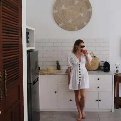 a woman in a white dress standing in a kitchen at Casa Sintra - Romantic, tranquil hideaway, walk to beach in Seminyak