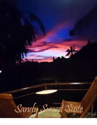 a view of a sunset with a chair and a table at Jayakarta Residence - Sandy Sunset Suite 1BR - 6432 in Seminyak