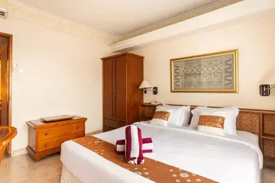 a bedroom with a large white bed and a wooden cabinet at Jayakarta Residence - Sandy Sunset Suite 1BR - 6432 in Seminyak