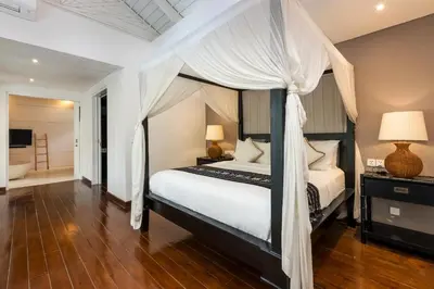 a bedroom with a canopy bed and a bathroom at Villa Iluka by SooBali in Seminyak