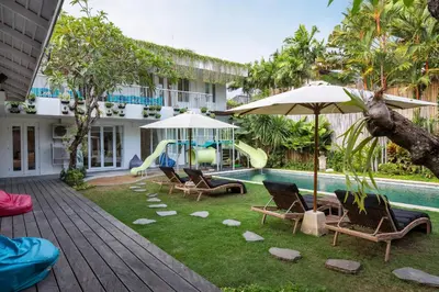 a resort with a pool and chairs and a slide at Villa Iluka by SooBali in Seminyak