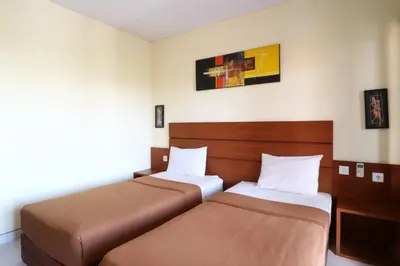 a room with two beds in a room at Kondra Premiere Guest House Kuta in Kuta
