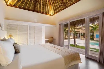 a bedroom with a bed and a view of a pool at Villa Surga Blue by Alfred in Bali in Seminyak