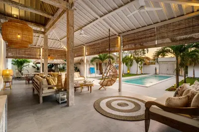 a living room with a swimming pool and a house at Villa Surga Blue by Alfred in Bali in Seminyak
