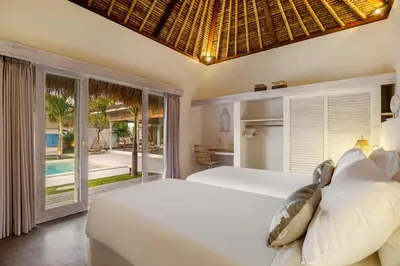 a bedroom with two beds and a view of the pool at Villa Surga Blue by Alfred in Bali in Seminyak