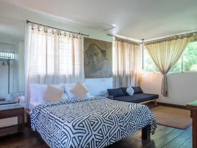 a bedroom with a king sized bed and a couch at Ocean Star 1 in Seminyak